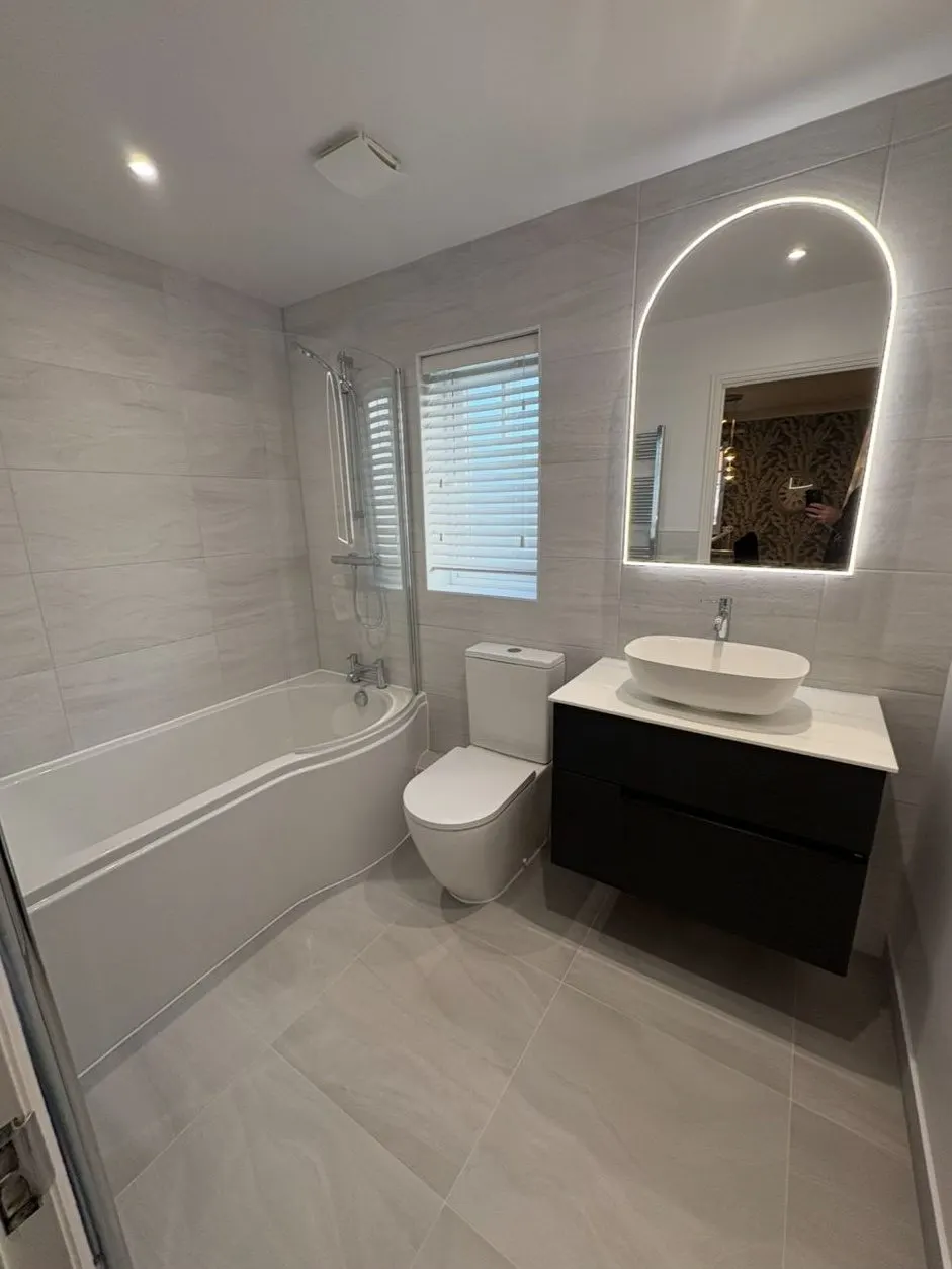 New bathroom installation in Reading with P-shaped shower bath, back-to-wall toilet and lit arched mirror