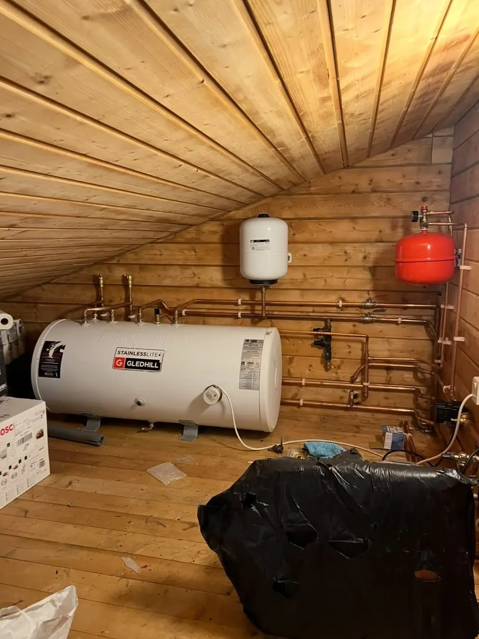 Horizontal unvented hot water cylinder with new copper pipework and expansion vessels in a loft