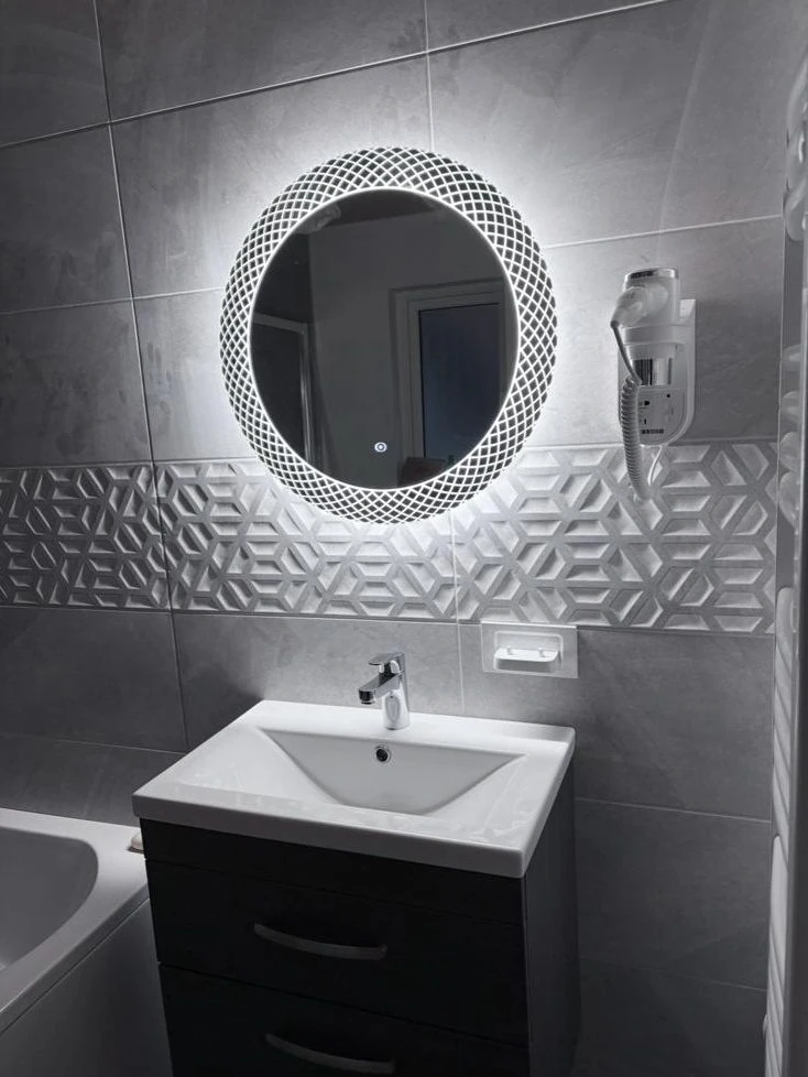 Fitted vanity basin with illuminated round mirror and feature tile band, bathroom installer Reading